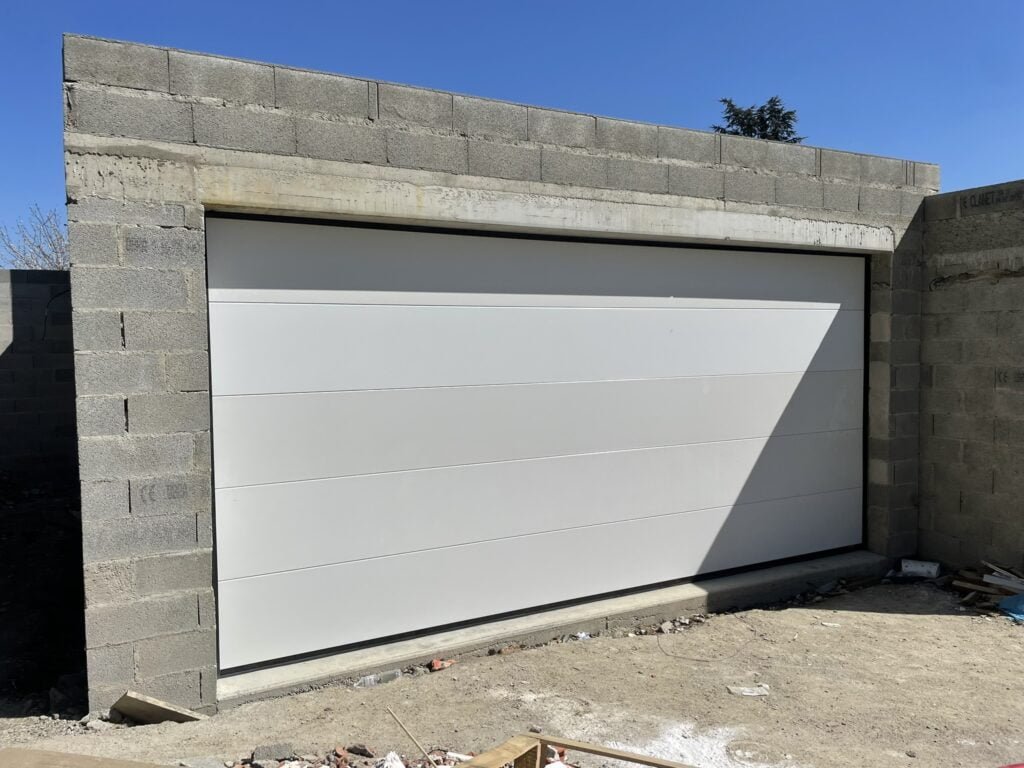 Portails sectionnels blancs motorisés installés à Saint-Pierre-de-Lages (31570) par GPA Automatisme. Sécurisation et esthétique moderne pour une entrée élégante