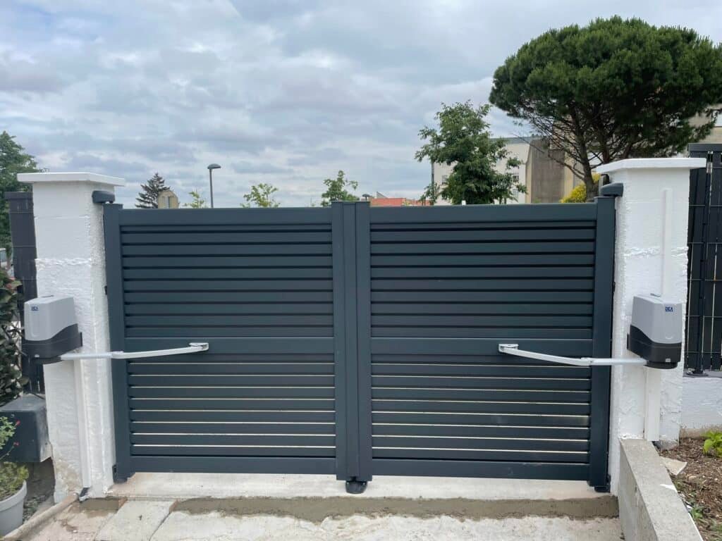 Portail battant gris motorisé installé à Cambiac (31460) par GPA Automatisme. Sécurisation et modernité avec une motorisation performante et un design élégant.