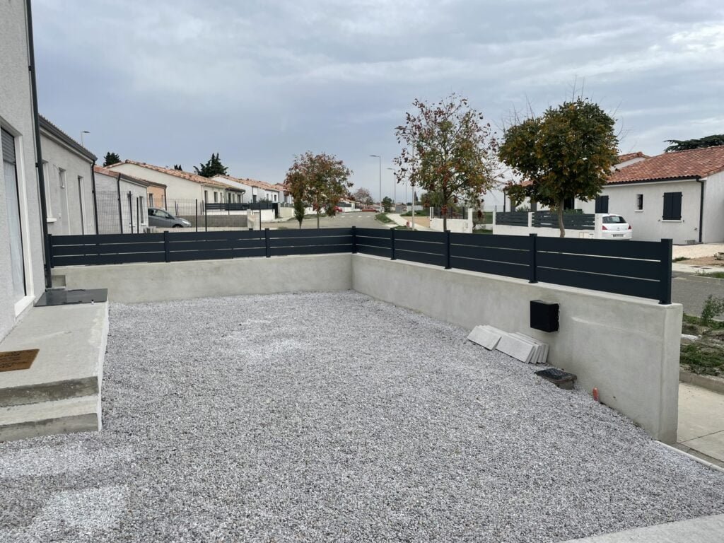 Clôture grise légèrement ajourée installée pour particulier à Caraman (31460) par GPA Automatisme. Solution élégante et discrète pour sécuriser votre jardin ou terrasse