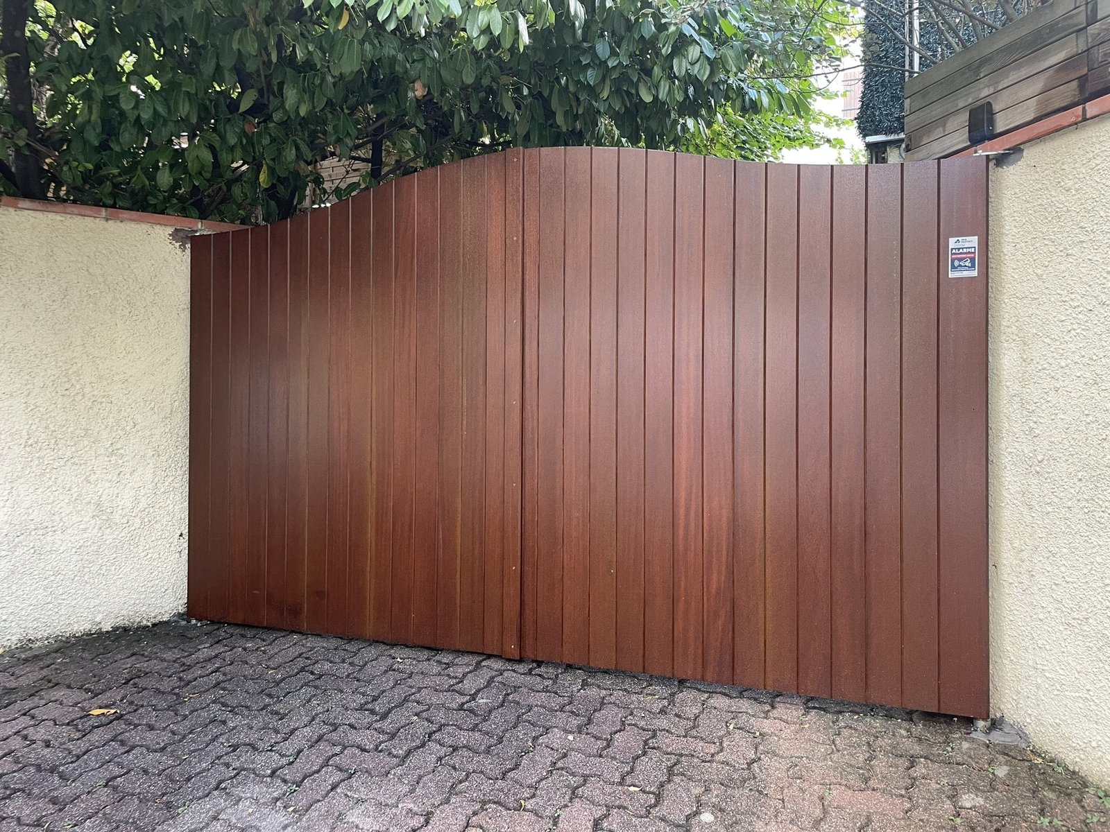 Portail battant motorisé imitation bois installé à Lanta (31570) par GPA Automatisme. Élégance du bois avec la robustesse et la durabilité d’un matériau moderne.