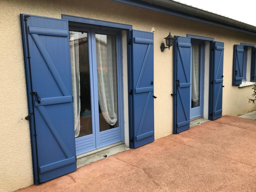 Volets battants bleus avec précadre en aluminium installés à Cambiac (31460) par GPA Automatisme. Sécurisation et design moderne pour une entrée élégante et résistante.