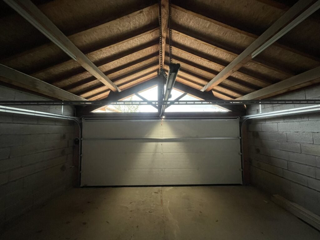 Portail sectionnel blanc motorisé installé à Lavaur (81500) par GPA Automatisme. Sécurisation et design épuré pour une entrée moderne et lumineuse