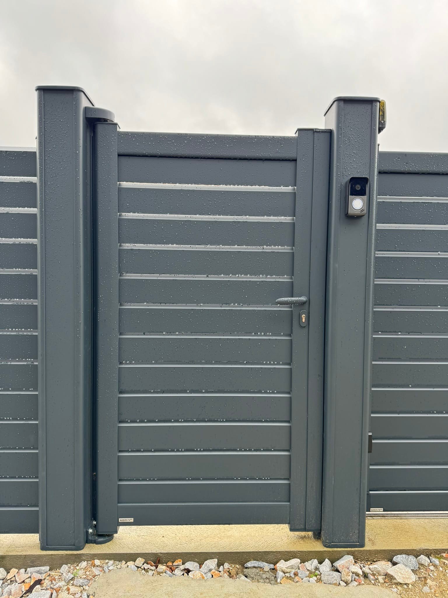 Portail, clôture et portillon gris ajouré avec portier vidéo installés à Saint-Germier (31290) par GPA Automatisme. Sécurisation et modernité avec un contrôle d’accès optimisé