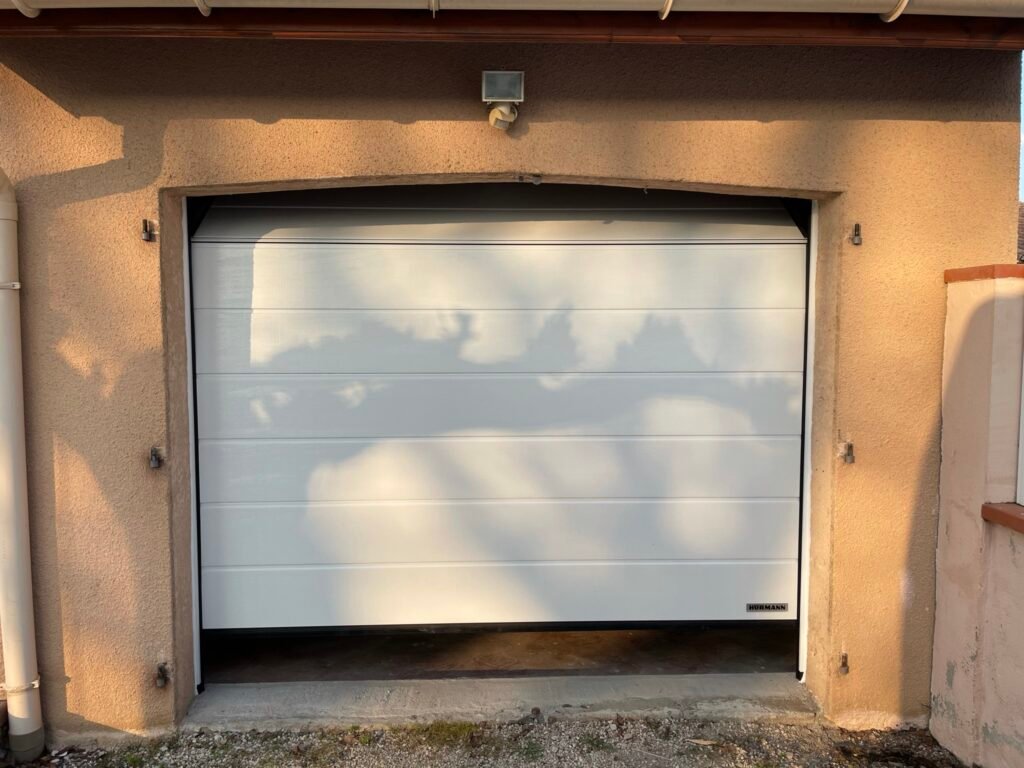 Portail sectionnel blanc motorisé installé à Lavaur (81500) par GPA Automatisme. Sécurisation et design épuré pour une entrée moderne et lumineuse.