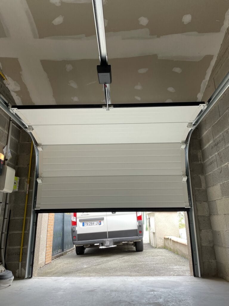 Portail sectionnel motorisé gris avec design moderne installé à Mascarville (31460) par GPA Automatisme. Sécurisation et esthétique pour une entrée pratique et élégante