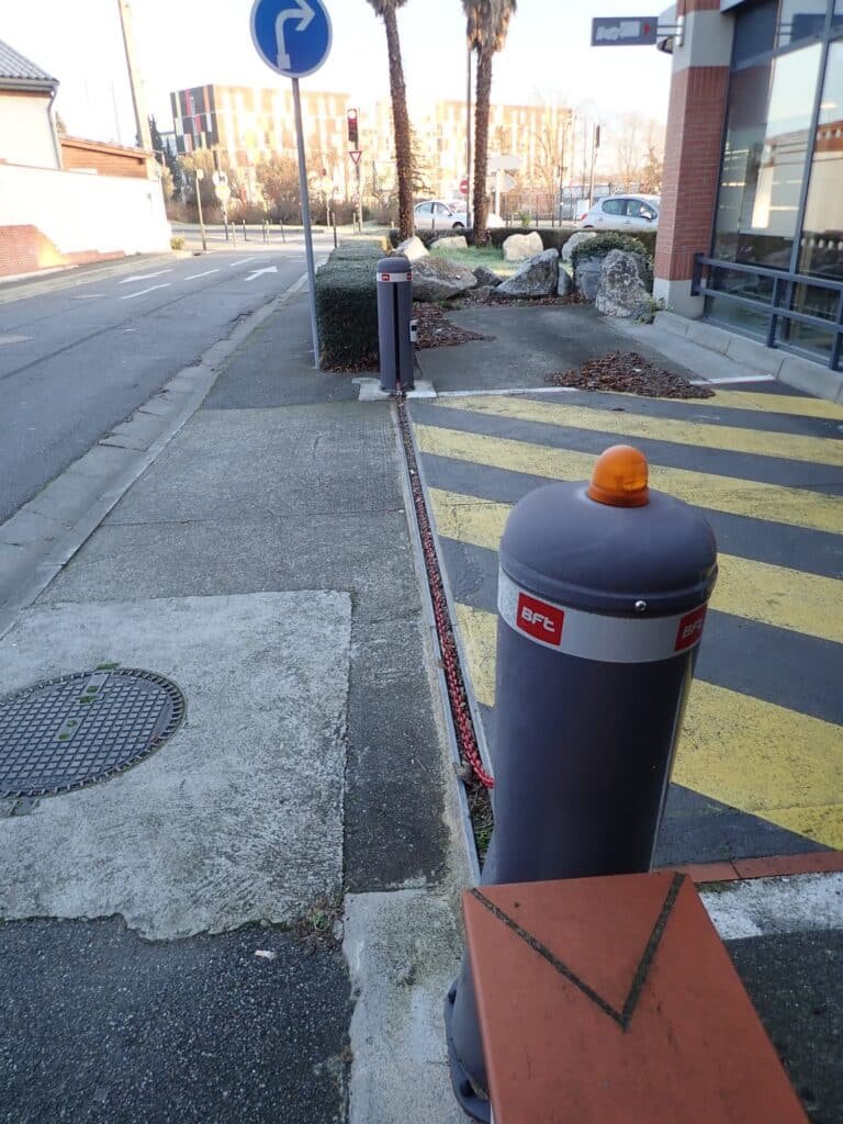 Lève-chaîne automatique installé à Nailloux (31560) par GPA Automatisme pour la sécurisation d’un parking professionnel. Alternative aux bornes escamotables, idéale pour contrôler l’accès.