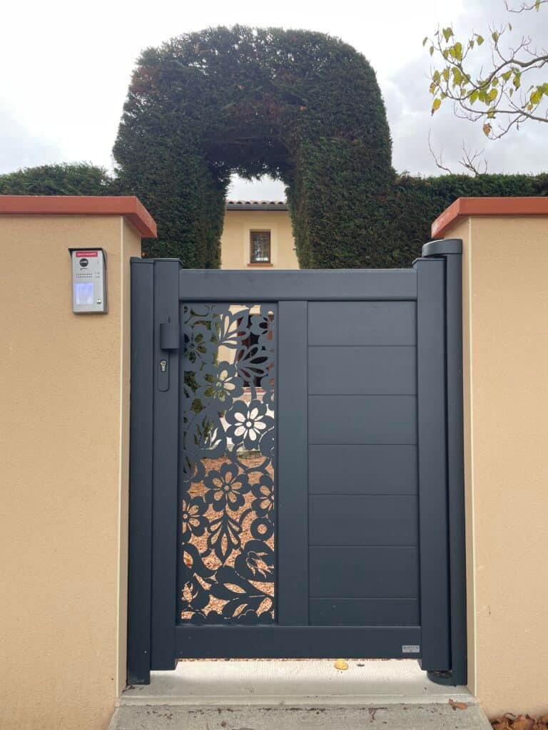 Portillon design en aluminium gris avec insert floral installé à Saint-Rome (31290) par GPA Automatisme. Élégance et modernité pour une entrée unique et sécurisée