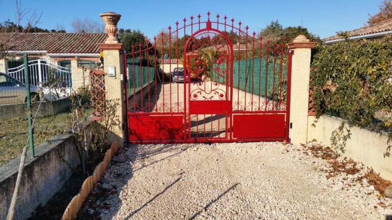 Portail battant rouge thermolaqué avec ouverture piétonne centrale installé à Caraman (31460) par GPA Automatisme. Pose et motorisation de portails sur mesure dans tout le Lauragais.